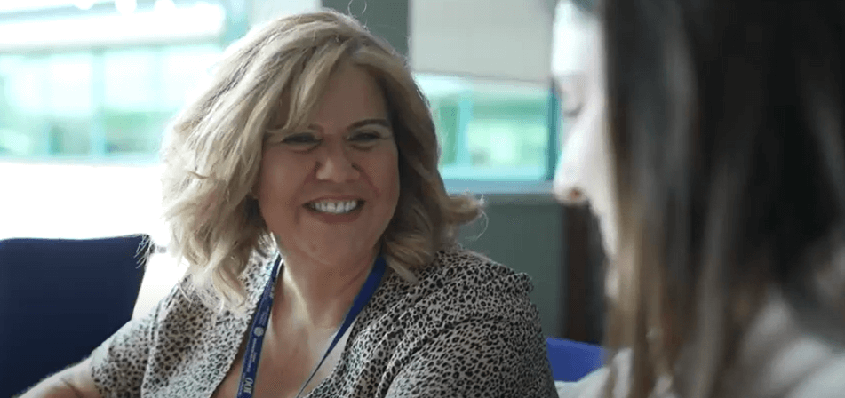 Lady smiling at another lady in an office