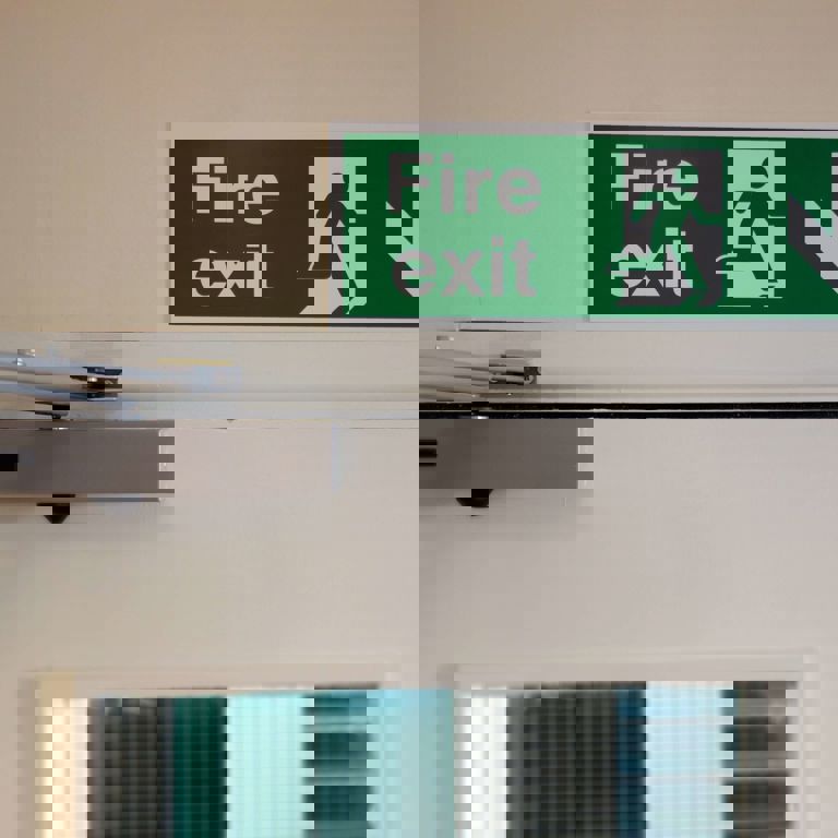 green fire exit sign above a exit door green fire exit sign above a exit door