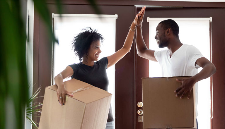 image of a man and a woman holding boxes and high fiving image of a man and a woman holding boxes and high fiving