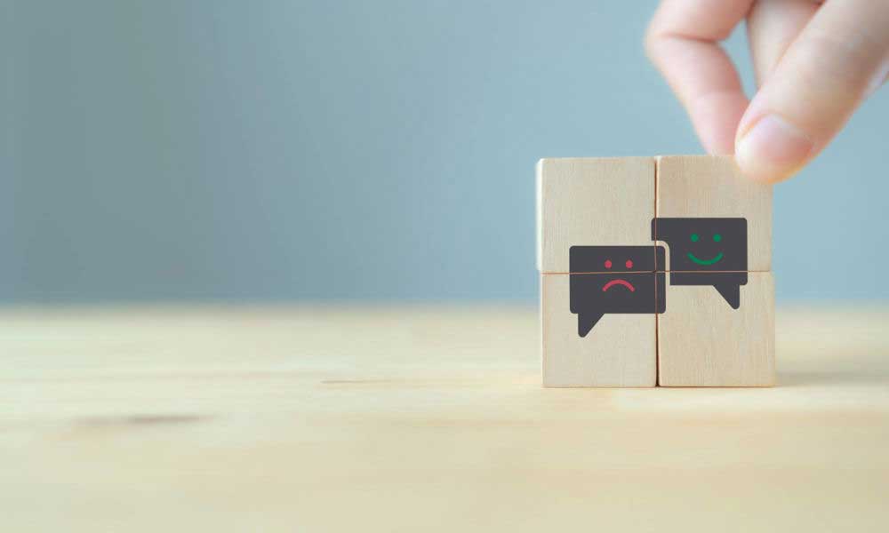 Man moving wooden smiley face froward