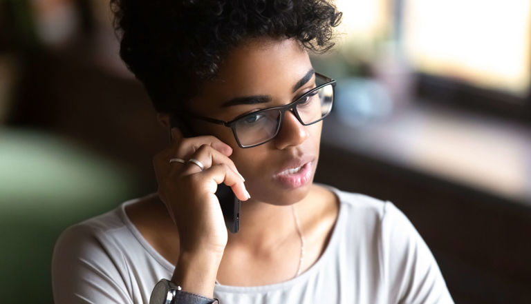lady wearing black glasses and a white shirt on her mobile phone lady wearing black glasses and a white shirt on her mobile phone