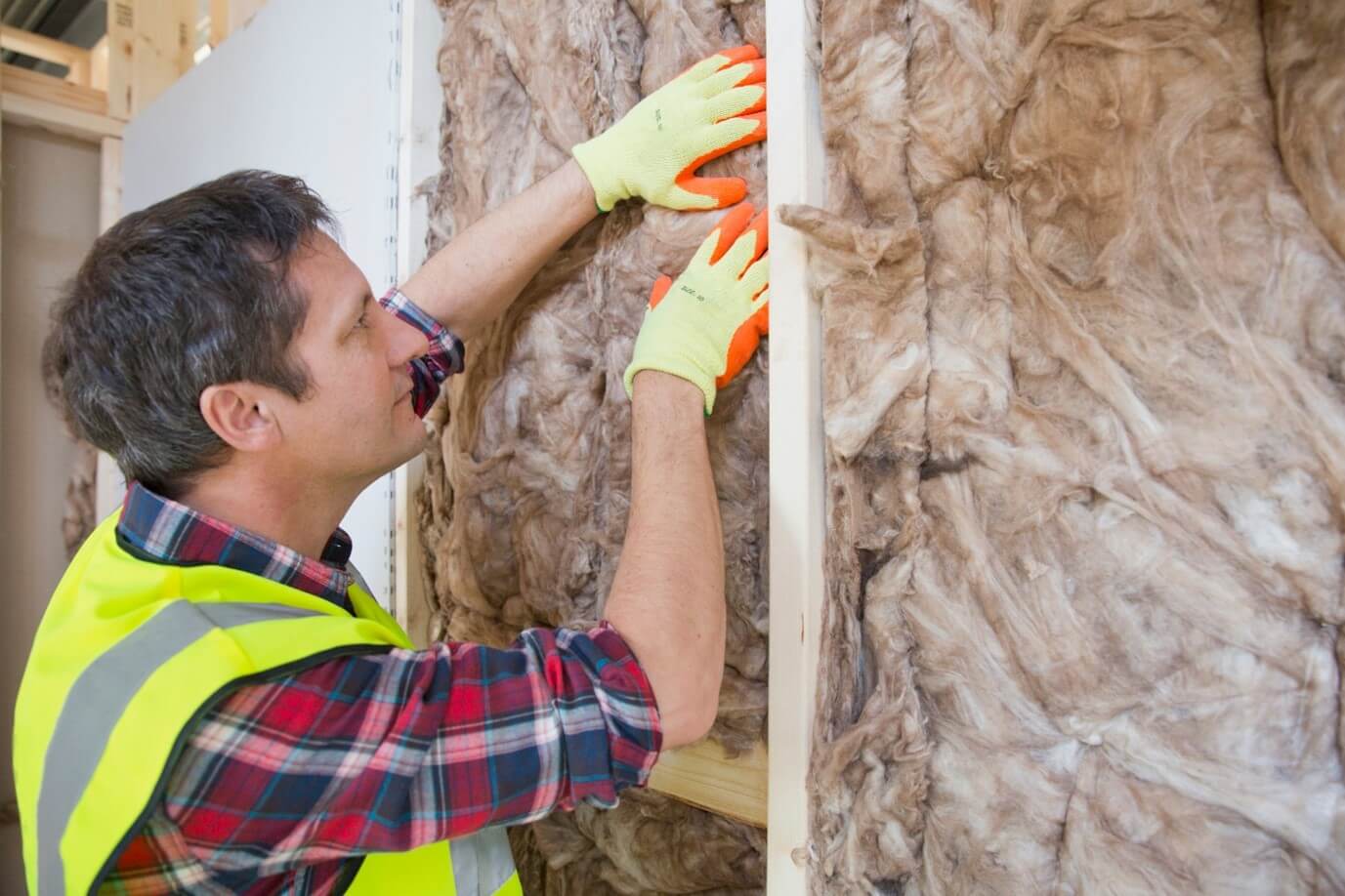 man fitting insulation wall padding on a wall