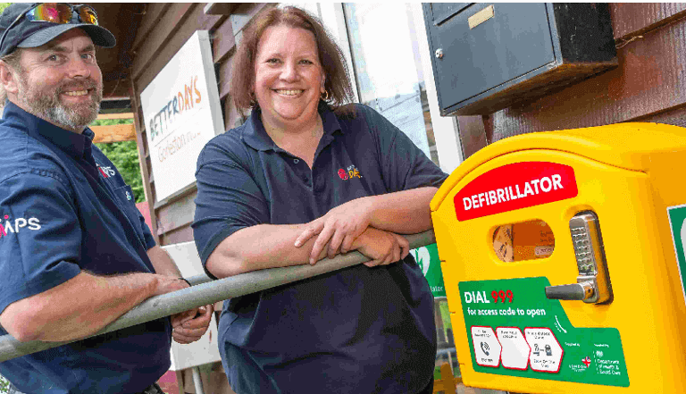 a man and woman standing next to a defibrillator a man and woman standing next to a defibrillator