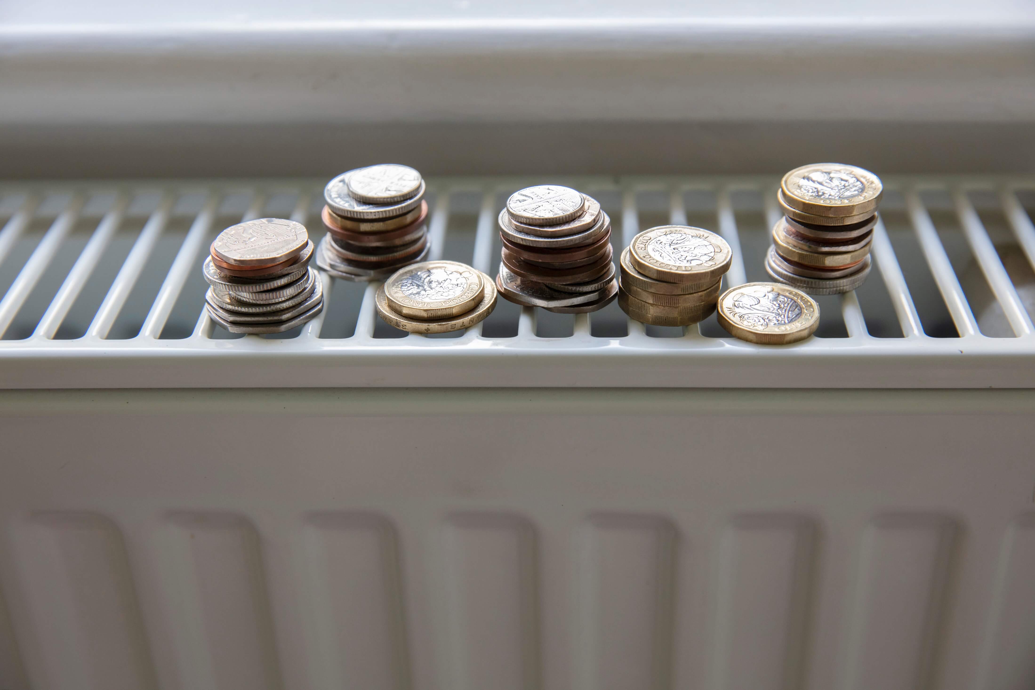 coins placed upon one another on a white heating radiator