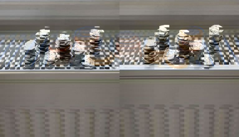 coins placed upon one another on a white heating radiator coins placed upon one another on a white heating radiator