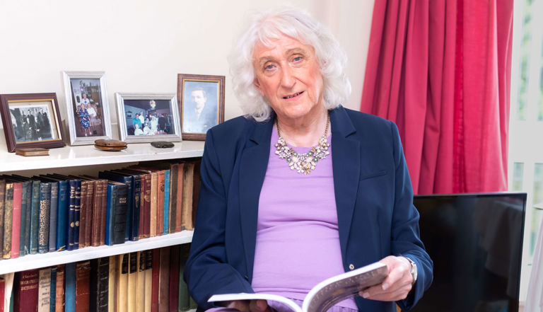 Sandra sitting in front of a bookcase reading a book Sandra sitting in front of a bookcase reading a book