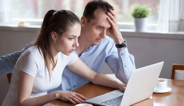 couple looking at laptop astonished couple looking at laptop astonished