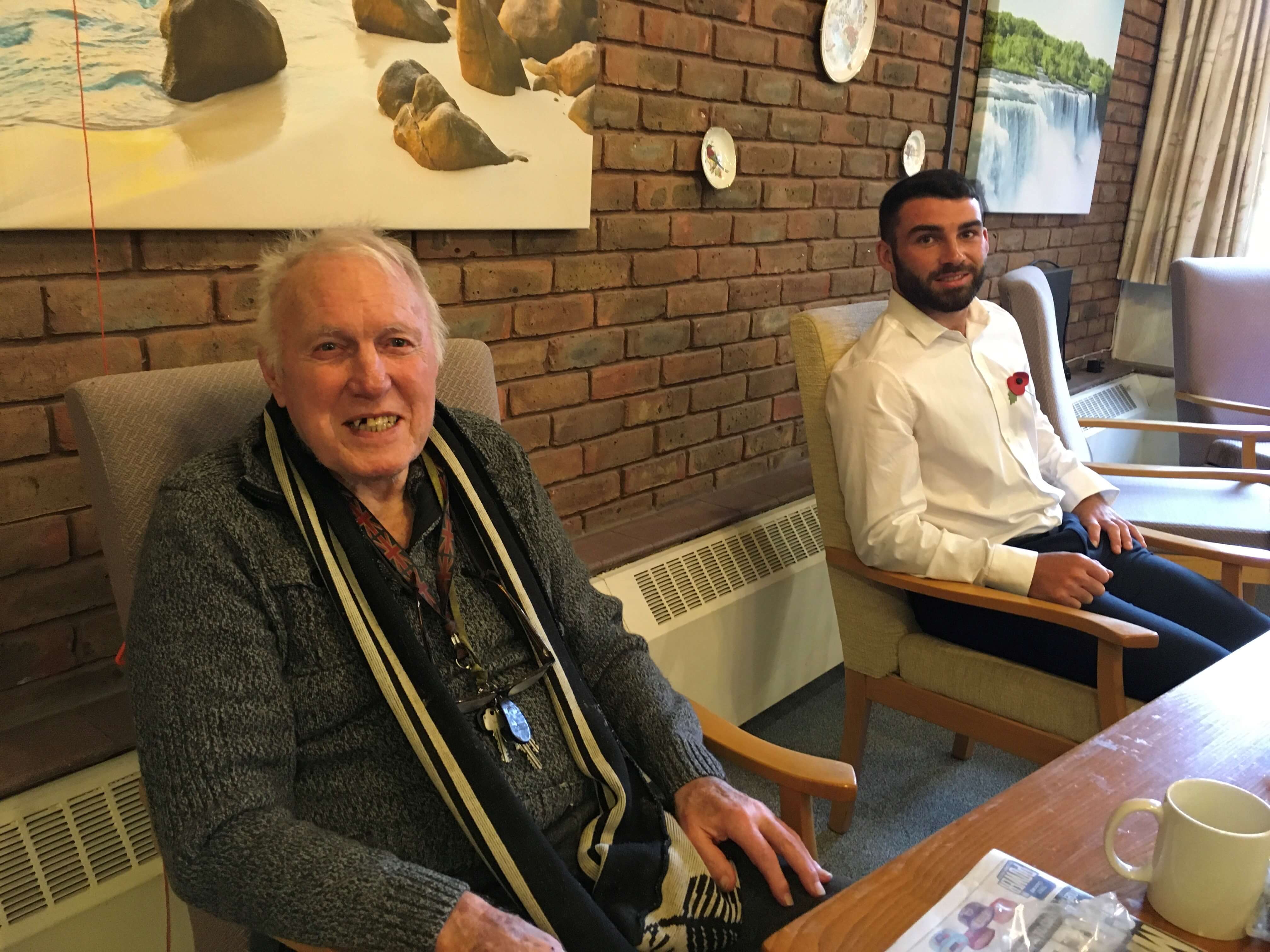 two men named John and David sitting in a lounge